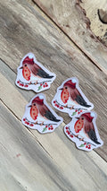 Quatre stickers illustrés de rouges-gorges portant un bonnet rouge, posés sur une branche de baies rouges, photographiés sur du bois clair.
